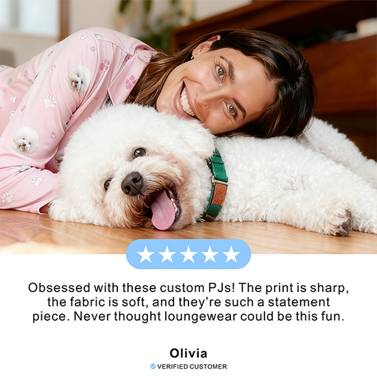 Woman in pink pajamas lying on the floor with a white dog, smiling.