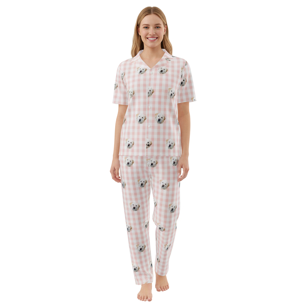 Woman wearing a pink checkered pajama set with dog pattern on a white background