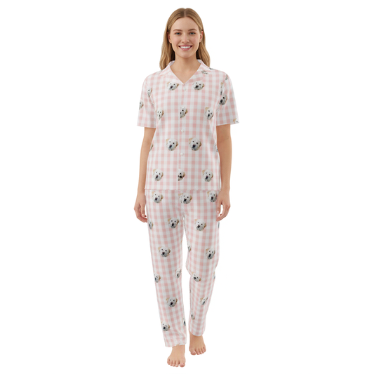 Woman wearing a pink checkered pajama set with dog pattern on a white background