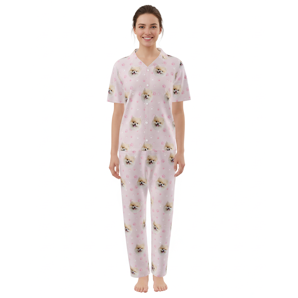 Woman wearing a pink pajama set with dog pattern on a white background