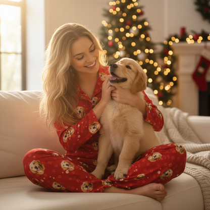 Woman in red pajamas with a dog on a couch in a cozy living room with Christmas decorations.