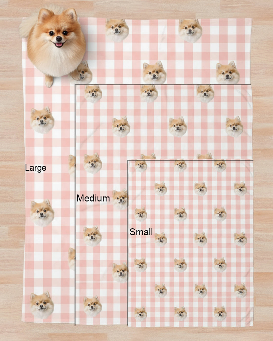 Pink checkered blanket with small dog illustrations and size labels on a wooden surface