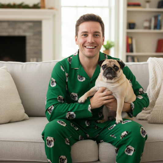 Man wearing green pajamas with dog patterns, holding a pug, in a living room.