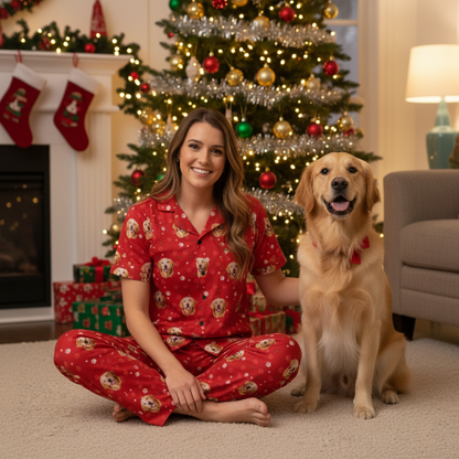 Woman in red pajamas with a dog in front of a Christmas tree and fireplace.
