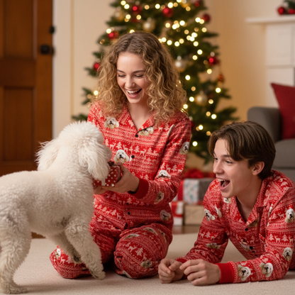 Two people and a dog in matching red pajamas in front of a Christmas tree.
