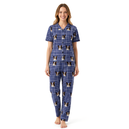 Woman wearing a blue checkered pajama set with dog print on a white background