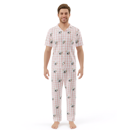 Man wearing a pink checkered pajama set with dog pattern on a white background