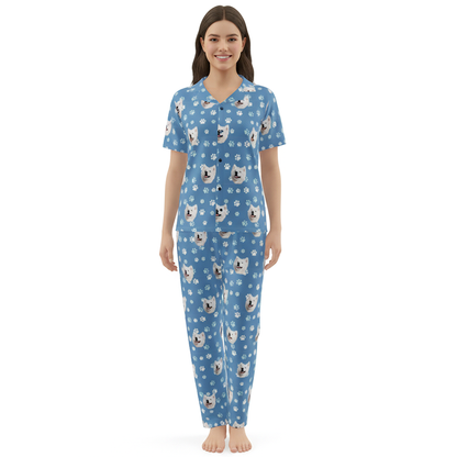 Woman wearing a blue pajama set with dog pattern on a white background