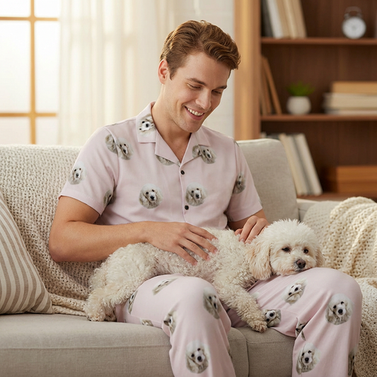 Man in pajamas holding a small white dog in a cozy living room.