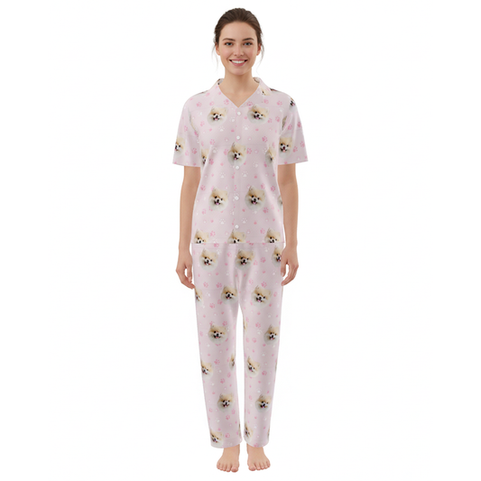 Woman wearing a pink pajama set with dog pattern on a white background